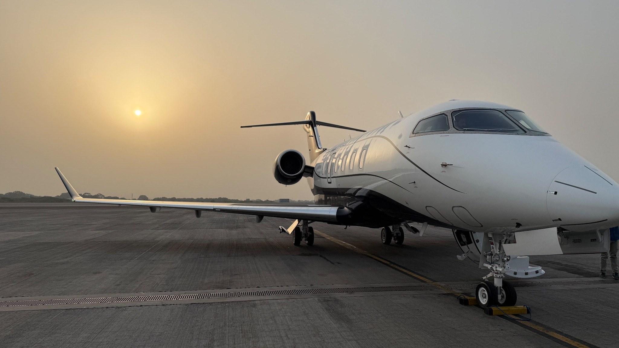 Luxury private jet on a runway in warm daylight